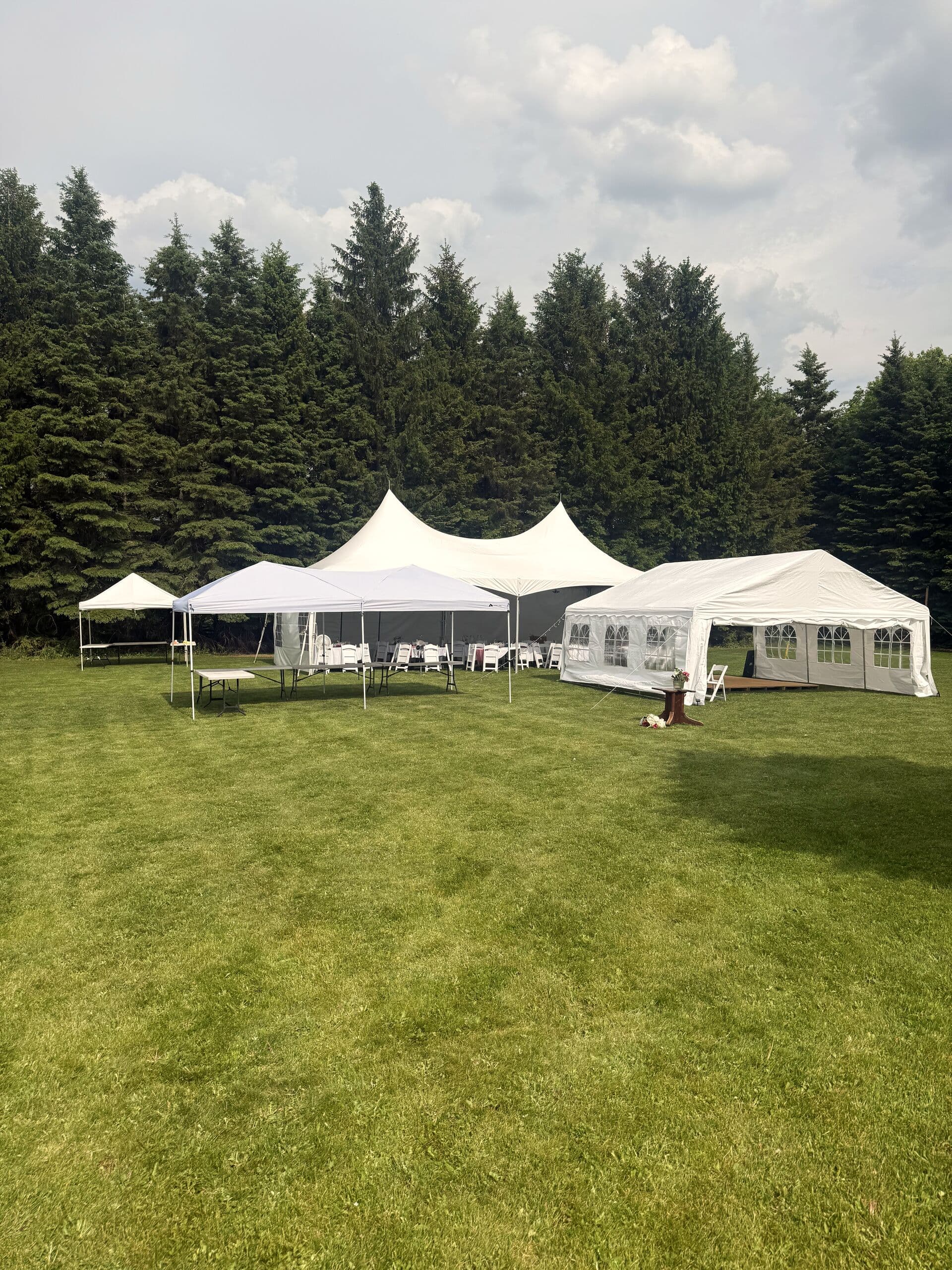 Multiple white frame tents set across the grounds at Rustic Hideaways